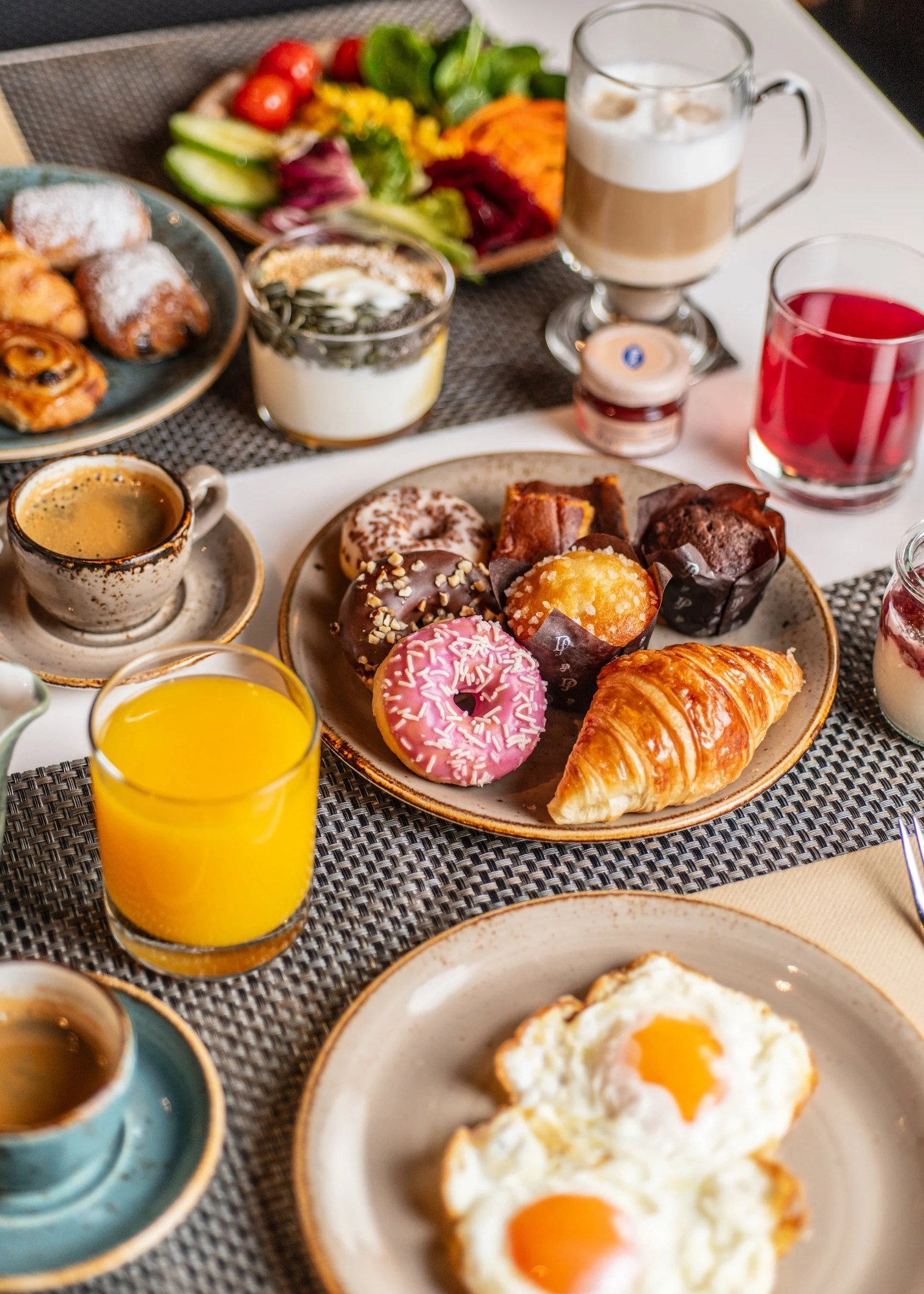 Mesa de desayuno con bollería, fruta, zumo y café recién hecho, la primera escena del día