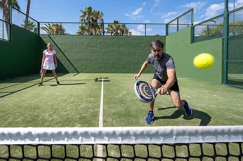 Huésped golpeando una bola en una pista de pádel del hotel