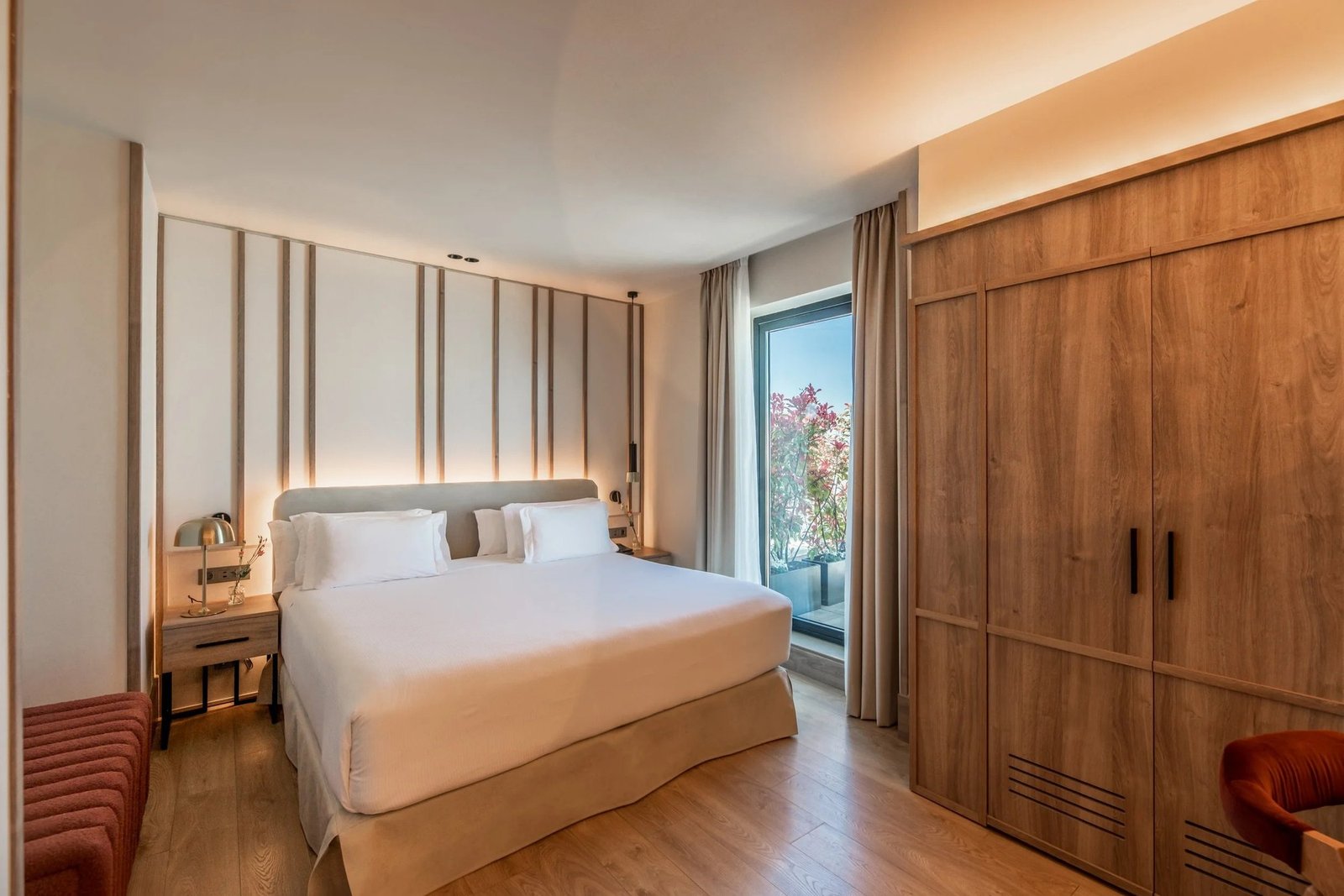 Habitación de hotel con cama doble y luz natural, una de las piezas del banco de contenido que se reparte a lo largo del año